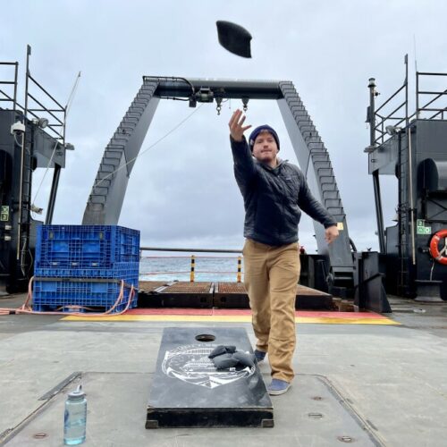 Scientist Kris Bauer tosses a bean bag during a game of cornhole