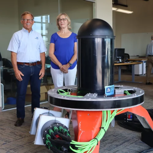 Tim and Bev Acker, CEO and CFO respectively of Biosonics, stand beside the Seattle company’s new ocean-bottom sonar device, which is designed to facilitate marine energy permitting by identifying and tracking nearby sea life.