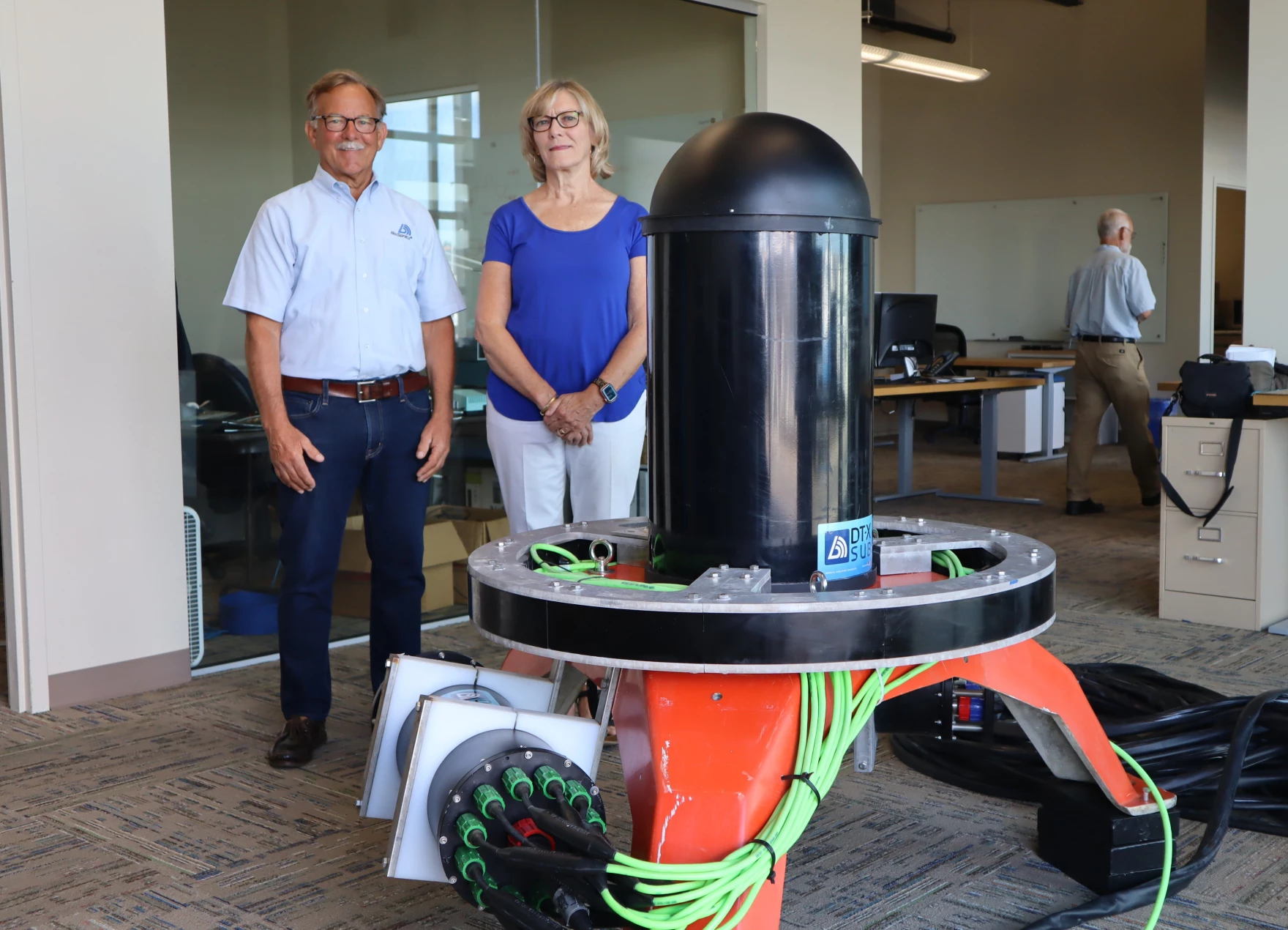Tim and Bev Acker, CEO and CFO respectively of Biosonics, stand beside the Seattle company’s new ocean-bottom sonar device, which is designed to facilitate marine energy permitting by identifying and tracking nearby sea life.
