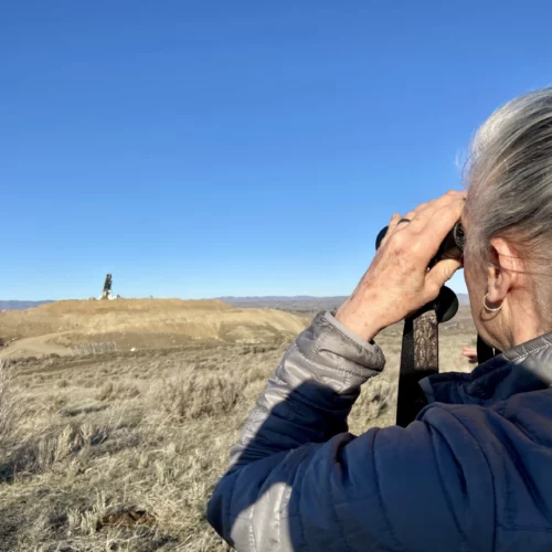 While hiking, Nancy Lust, with Friends of Rocky Top, watches a truck dump waste into a landfill in Yakima County. Lust lives near the landfill and has fought to learn more about what's getting disposed of near her home.