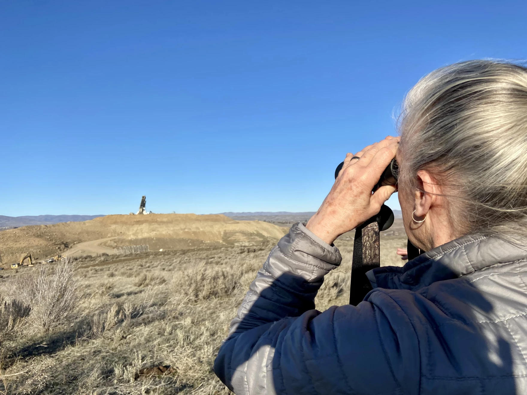 While hiking, Nancy Lust, with Friends of Rocky Top, watches a truck dump waste into a landfill in Yakima County. Lust lives near the landfill and has fought to learn more about what's getting disposed of near her home.