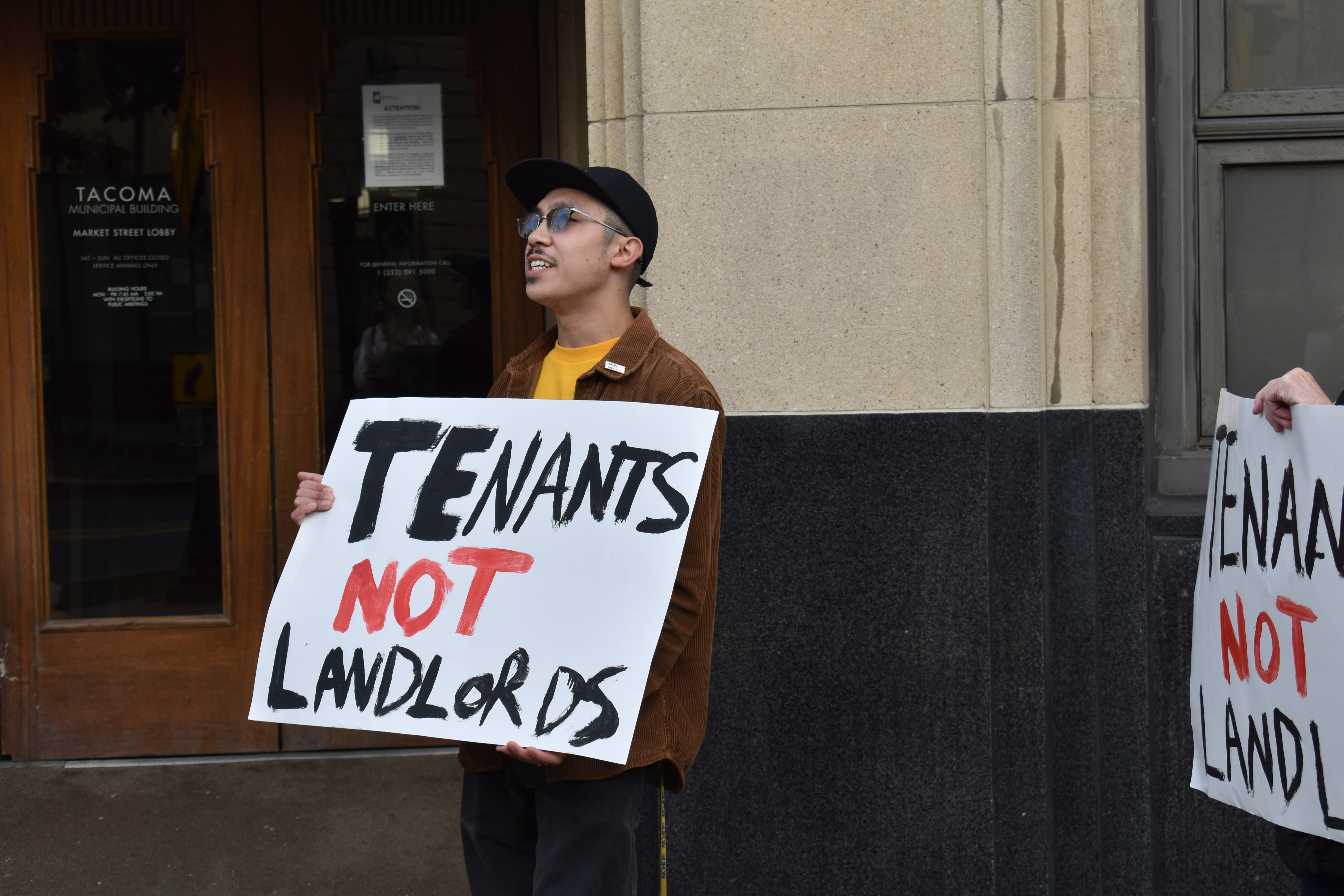 UFCW 367 member Michael Whalen, executive board member of the Pierce County Central Labor Council, holds a sign that reads "Tenants Not Landlords," at Tuesday's protest. Photo by Lauren Gallup.