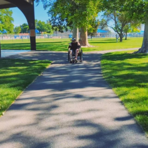 Jaime Torres in a wheel chair on a sidewalk.