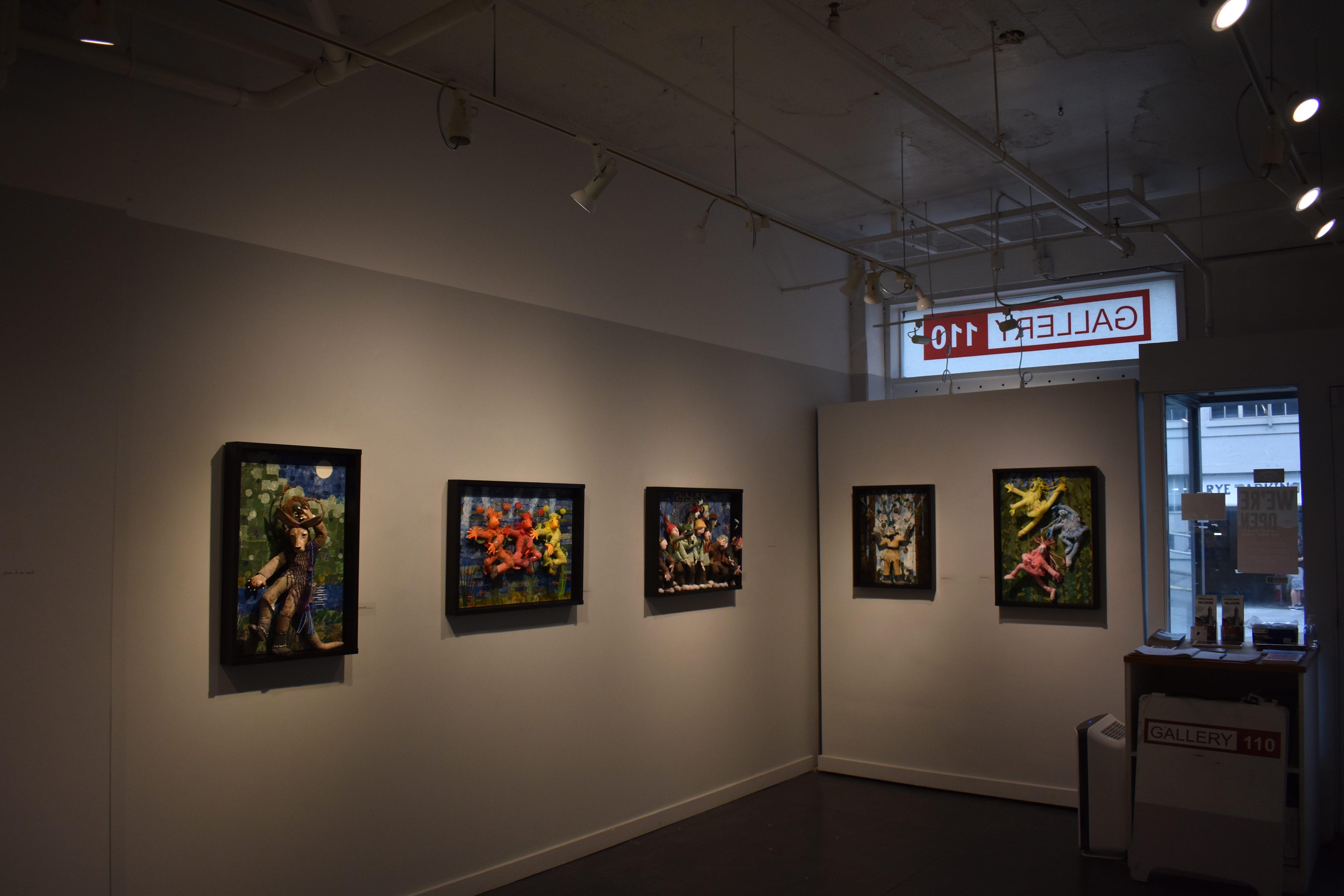 Two of the gallery walls, covered with Wasserman's sculptures. Photo by Lauren Gallup.