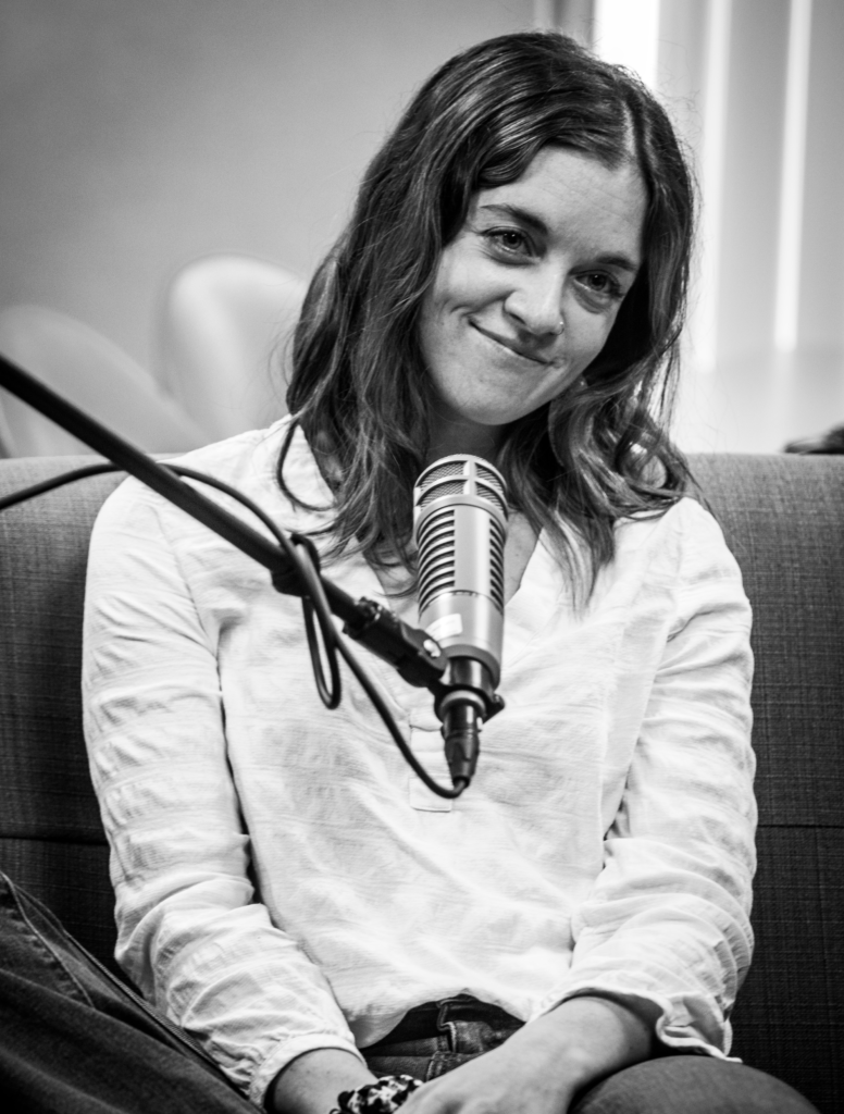 This is the featured image of Emerald LaFortune. She is smiling in front of a microphone.