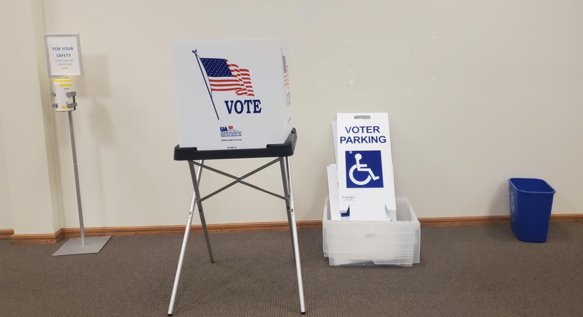 table with a voting booth, a disabled parking sign