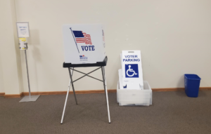 table with a voting booth, a disabled parking sign