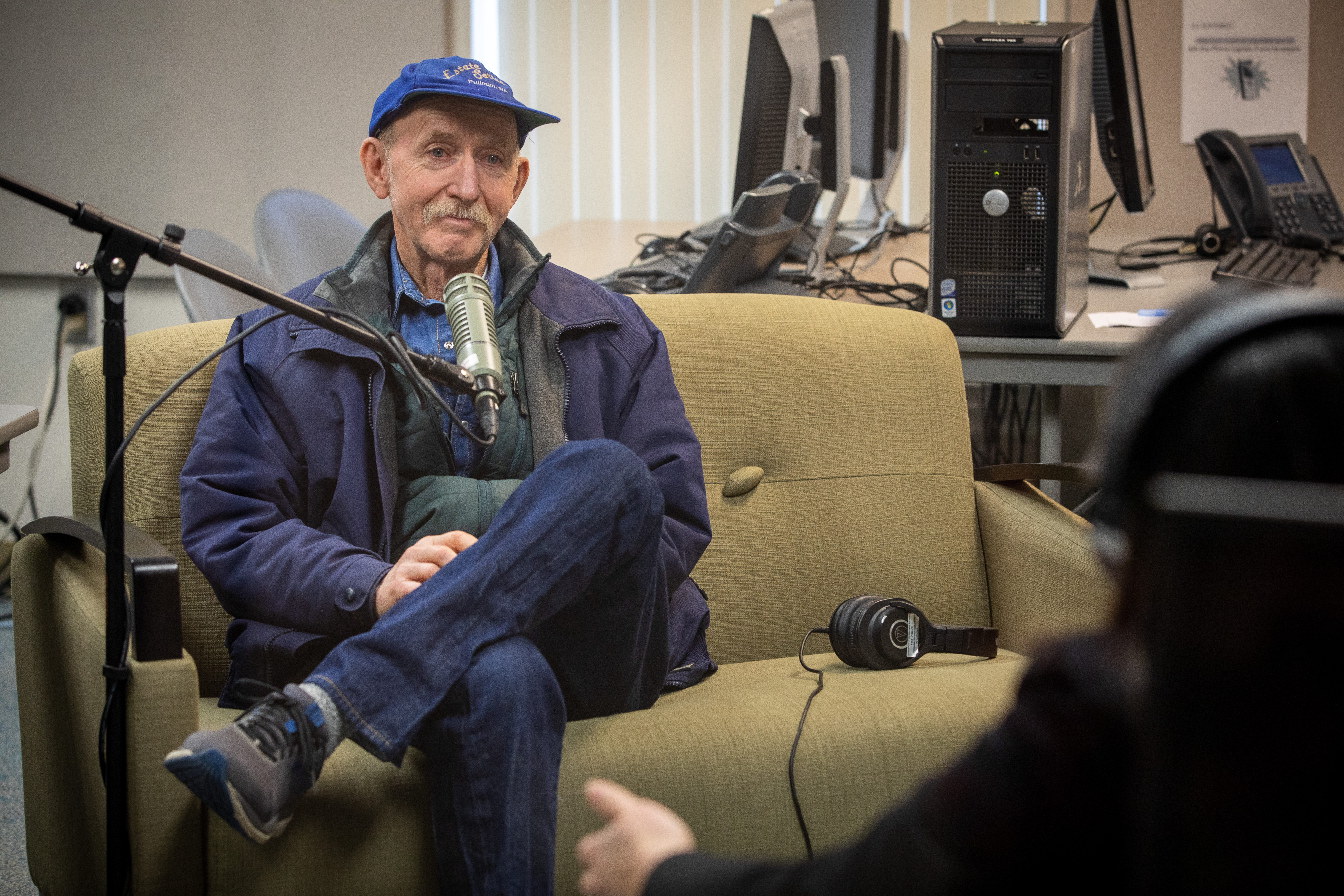 Podcast Guest Rich Old sits on a couch in front of a microphone.