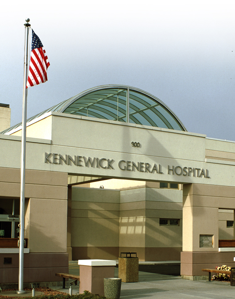 Front image of a hospital with an American flag and Washington state flag