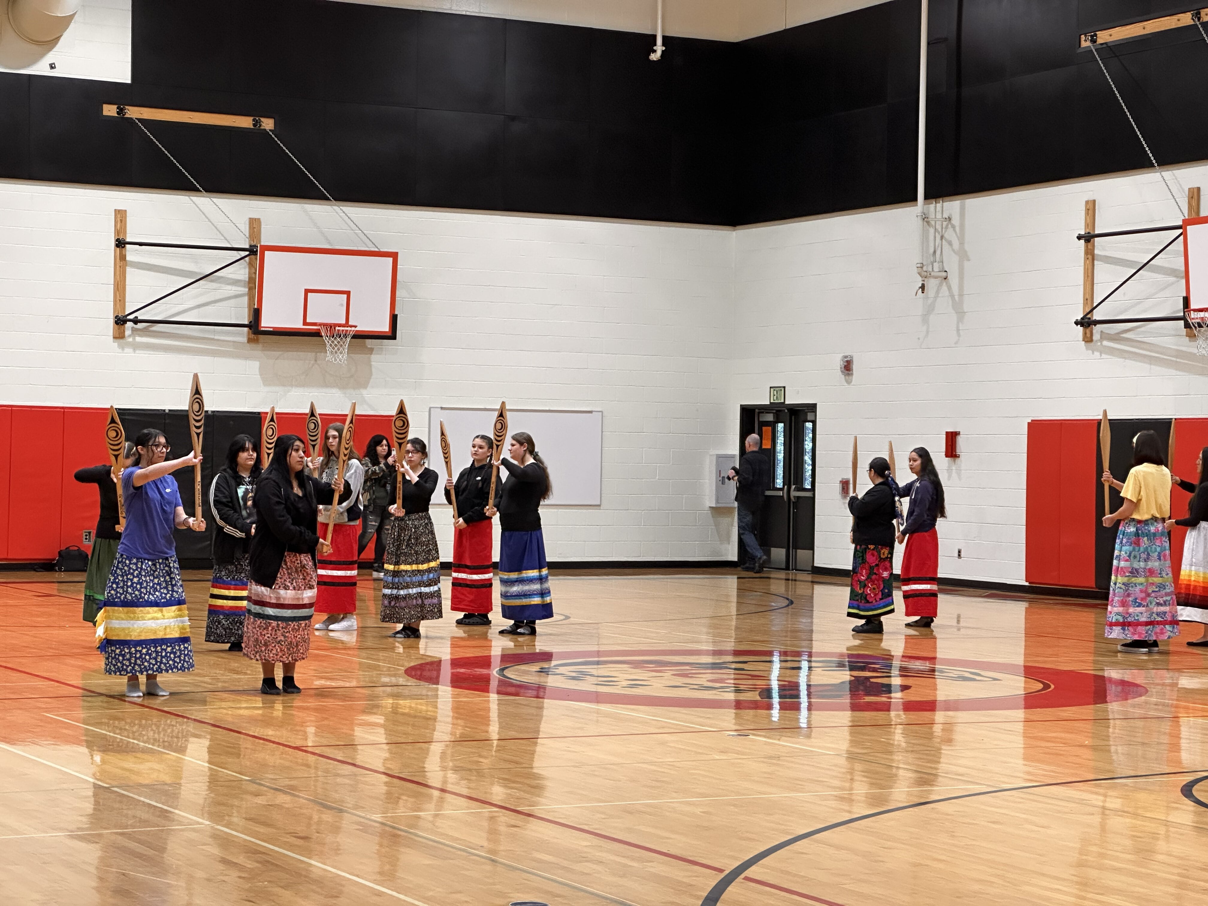 Dancers in ribbon skirts perform a paddle song. Photo by Lauren Gallup.