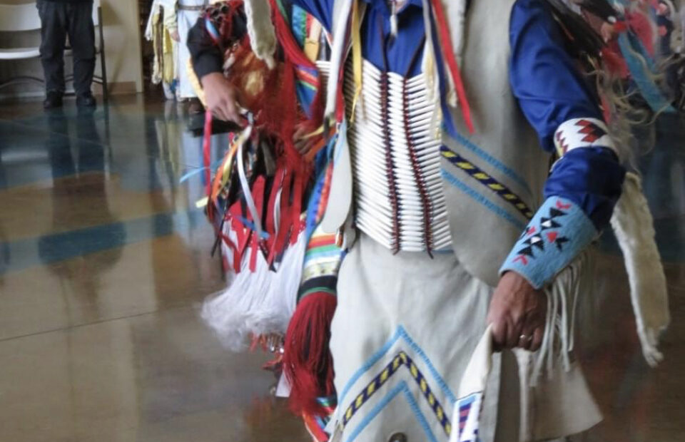 Native American man wearing traditional clothing used in a dance.