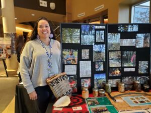 Native woman in front of display of photos