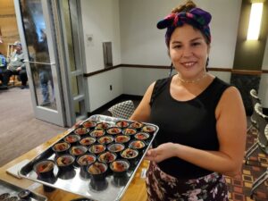 Native woman in colorful headscarf holding a tray of food