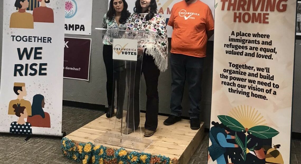 Three people stand on a podium