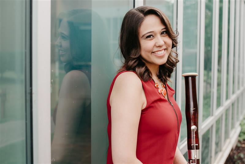 Bassoonist Dr. Jacqueline Wilson smiling with her instrument. Click here to hear the full story.