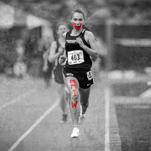 Rosalie Fish, running with a painted red handprint across her face and the letters "MMIW" along her leg to raise awareness of the Missing and Murdered Indigenous Women crisis. Photo courtesy of Fish.