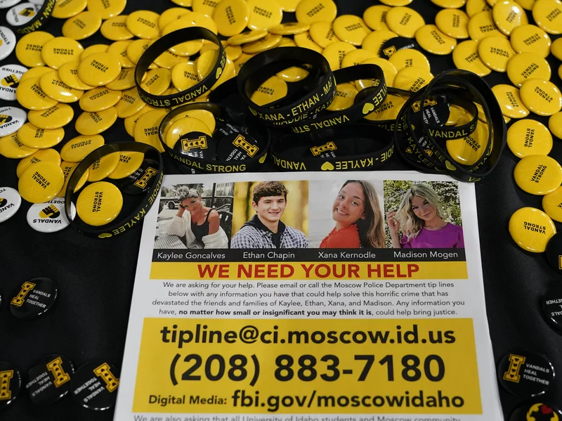 A flyer seeking information about the killings of four University of Idaho students who were found dead on Nov. 13, 2022, is displayed on a table along with buttons and bracelets, Wednesday, Nov. 30 during a vigil in memory of the victims in Moscow, Idaho.