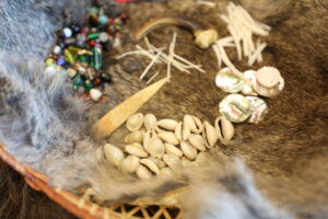 brightly colored beads, quills and bones laying on fur.