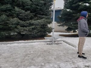 A man stands next to an ice-covered bus stop