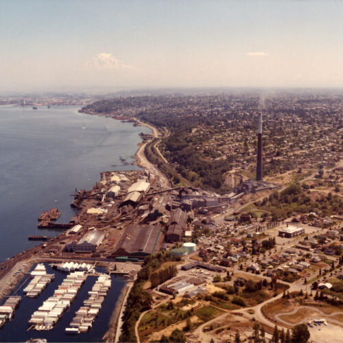 An image of the ASARCO smelter in Tacoma, showing the smokestack rising above the waterfront. Photo credit Tacoma Public Library.
