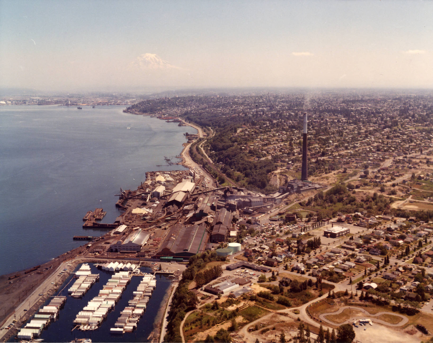 An image of the ASARCO smelter in Tacoma, showing the smokestack rising above the waterfront. Photo credit Tacoma Public Library.