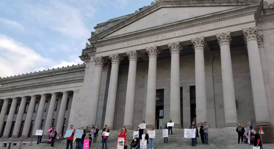 Demonstrators stand on the steps of the Washington Statehouse to show their support for House Bill 1397 a week before its first scheduled committee hearing