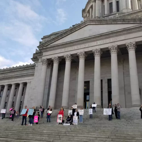 Demonstrators stand on the steps of the Washington Statehouse to show their support for House Bill 1397 a week before its first scheduled committee hearing