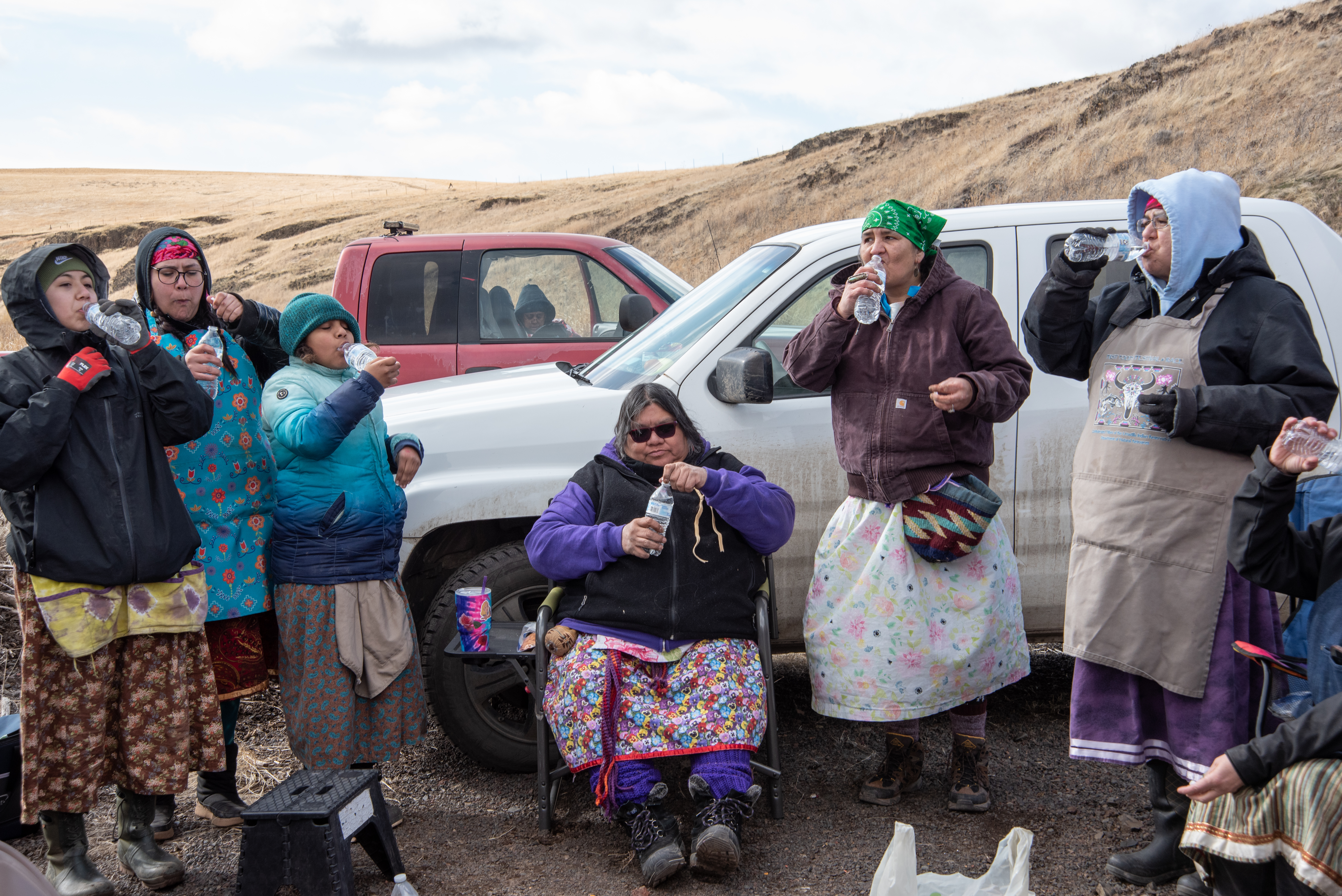 Tatum Ganuelas, Jill-Marie Gavin, Lisa Faye McIntosh-Gavin, Shawna Gavin, Jolie Wendt, and LeAnn Alexander, from left to right, finish their picnic lunch with a drink of water, or cuus. They started off the meal with a taste of the tribes’ traditional First Foods: salmon, meat, roots, chokecherry, and huckleberries. The meal began and ended with water in acknowledgement of the vital role it plays for all living things on earth 