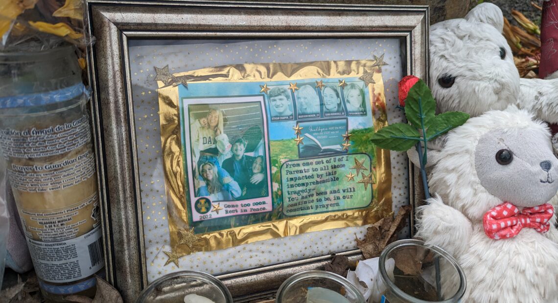 Candles, stuffed toy lambs and a framed photo of the four students sits atop grey rocks in front of the King Road house.