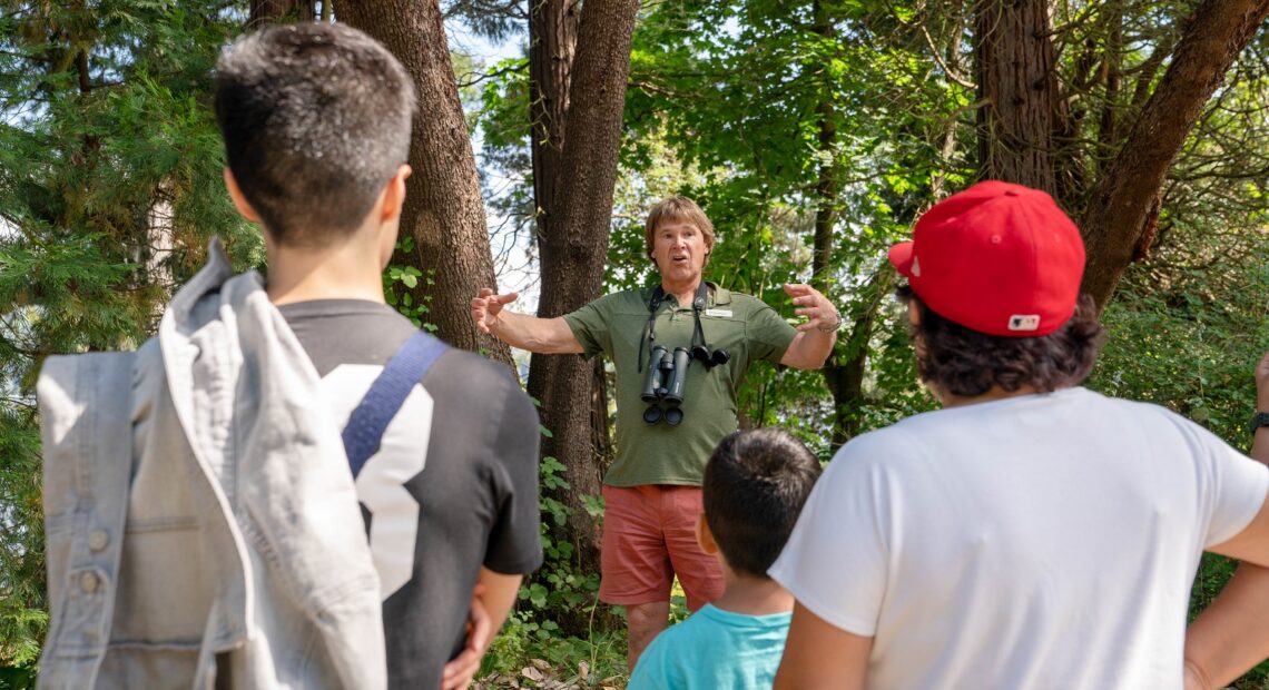 A man guides young people on a park tour