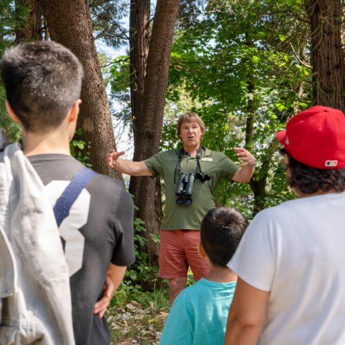 A man guides young people on a park tour