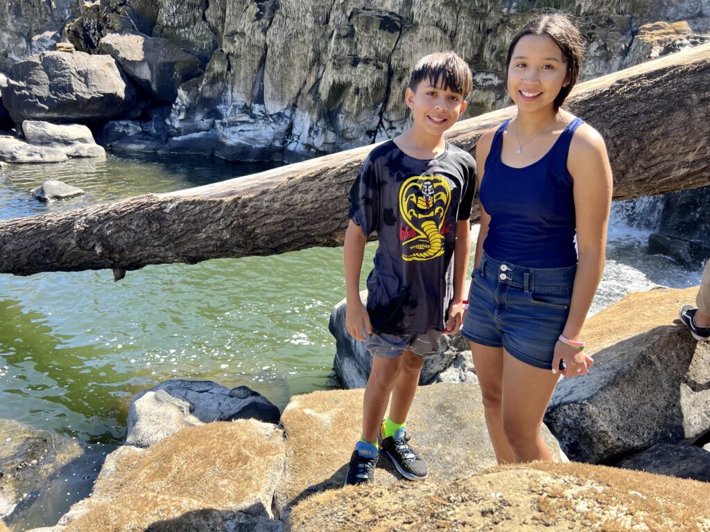 Miracle Edmiston, 14, and her brother, Eagle, 12, searched Willamette Falls for lamprey. Students from the Confederated Tribes of the Umatilla Indian Reservation hoped to gather lamprey before the celebration officially began. (Credit: Courtney Flatt.)
