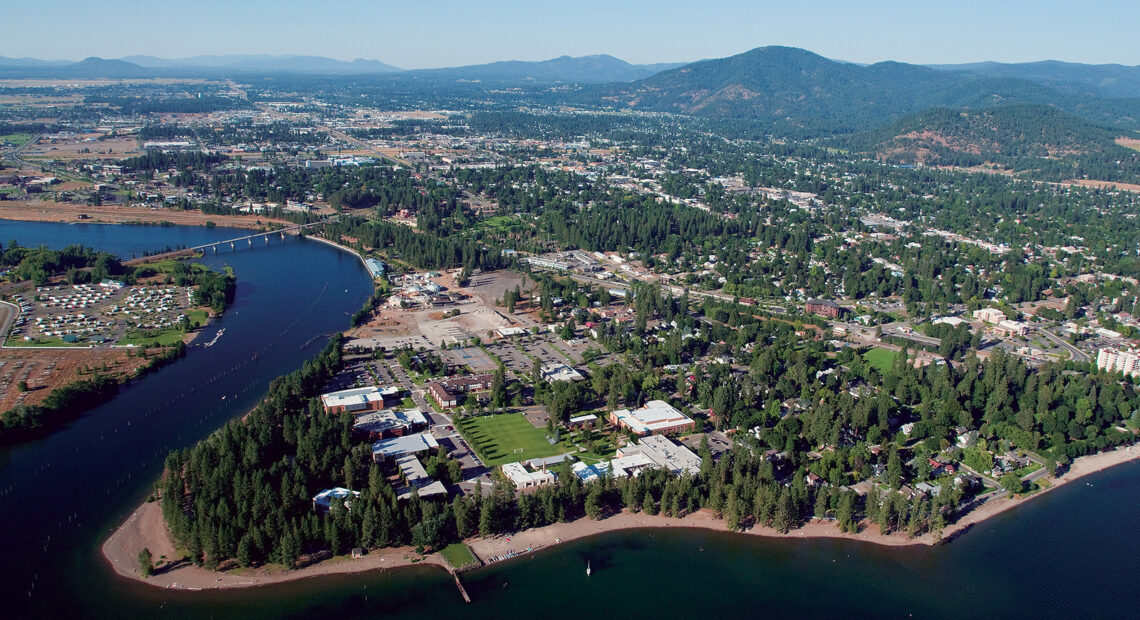 A drone photo shows the North Idaho College Campus along the shores of a lake surrounded by trees.