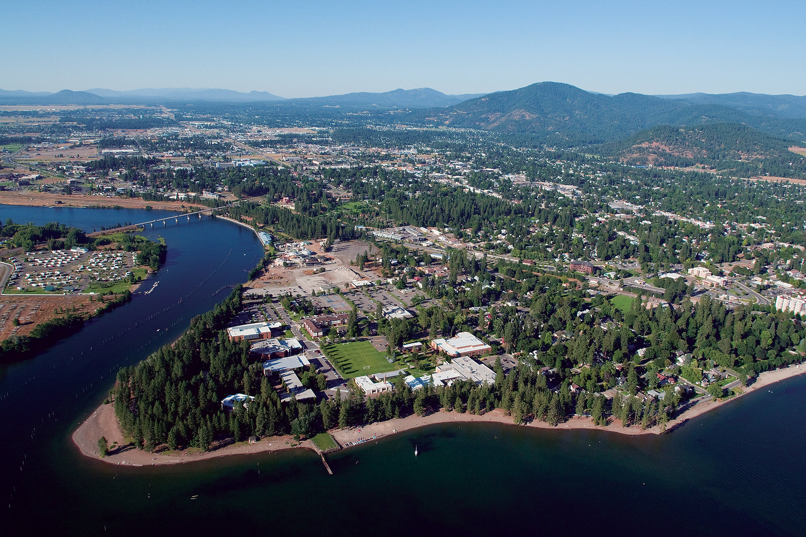 A drone photo shows the North Idaho College Campus along the shores of a lake surrounded by trees.