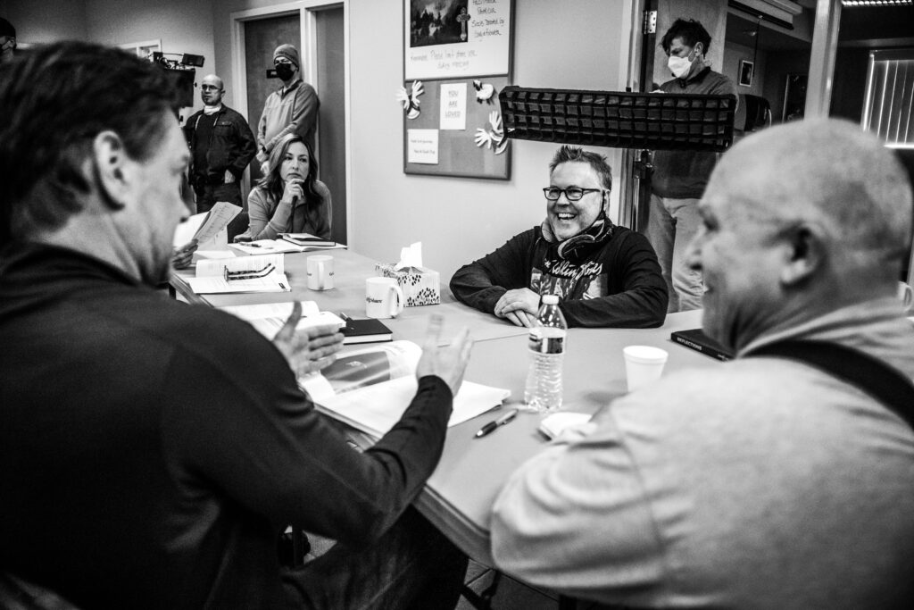 Dan Merchant, cast and crew sit around a table on the set of "Going Home" in Spokane, Washington. 