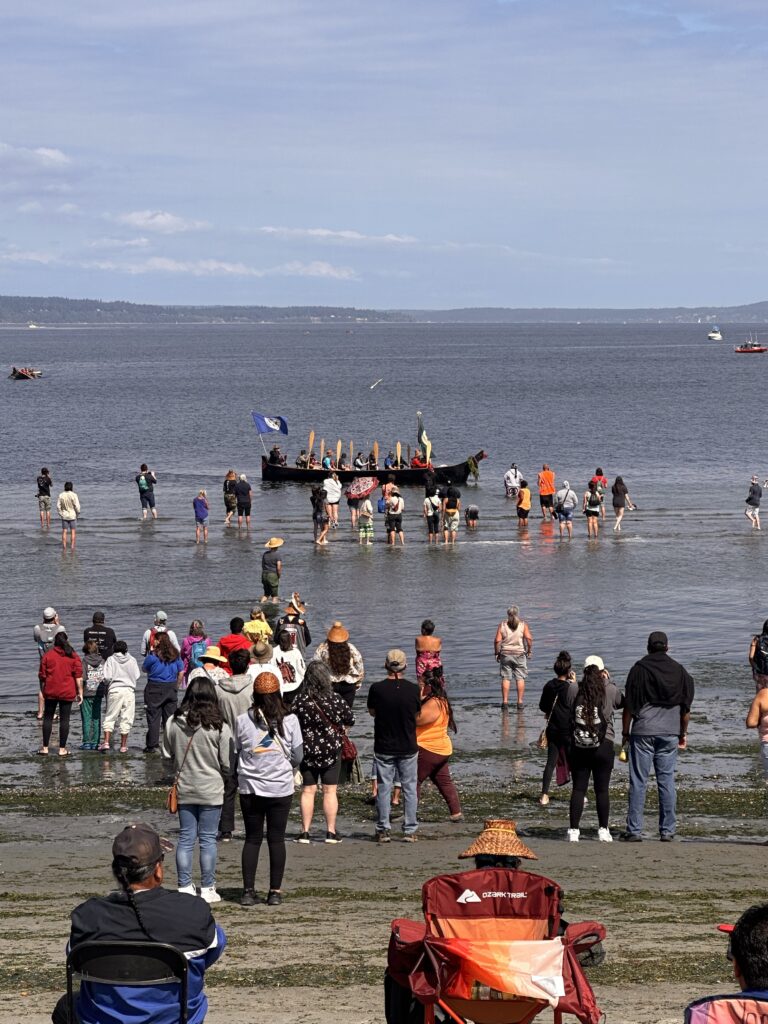 As the canoes came in, people on the shore waded into the water to greet them. // CREDIT: Lauren Gallup, NWPB
