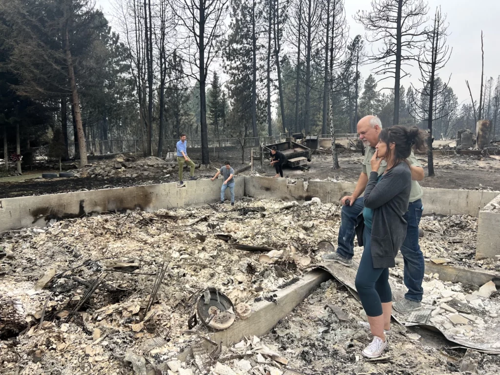 Mike and Stephanie Zappone comfort each other recently amid the ashes of their home in Medical Lake