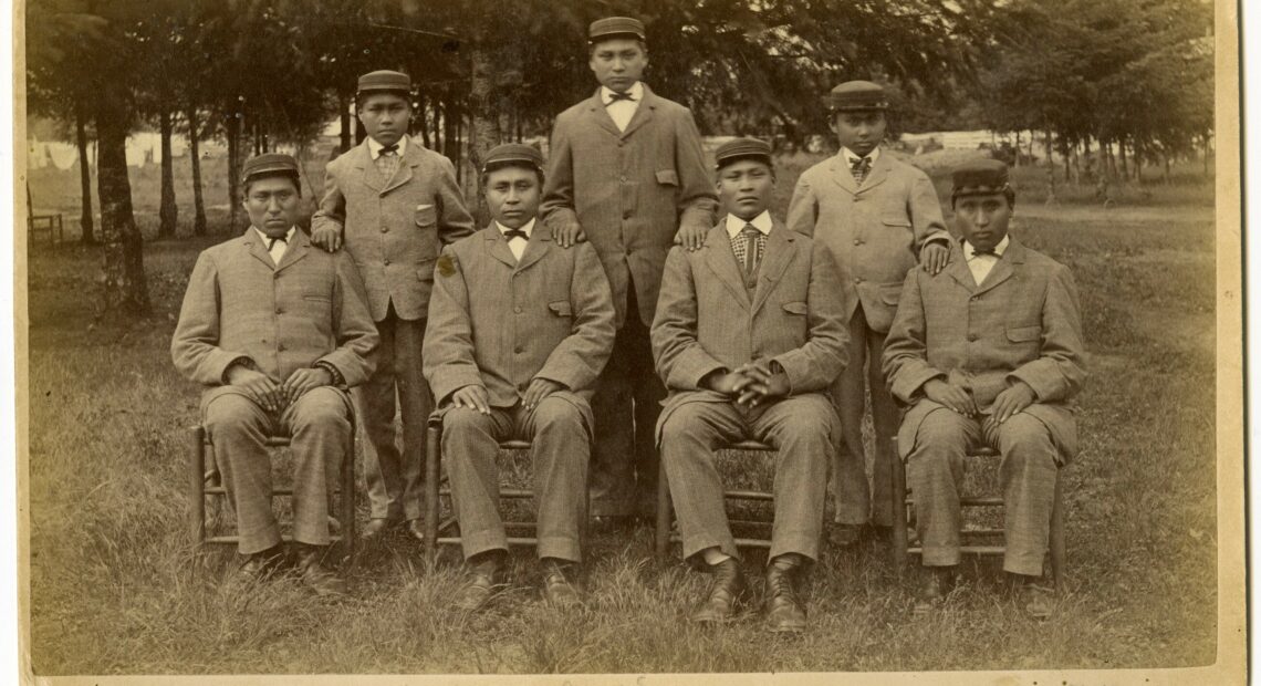 This historical photo, provided to Oregon Public Broadcasting by Pacific University archivist Eva Guggemos, shows seven boys who came to the Forest Grove Indian Training School from the Spokane tribe in 1880. The Forest Grove school operated for a few years before being relocated to Salem and renamed Chemawa Indian School.