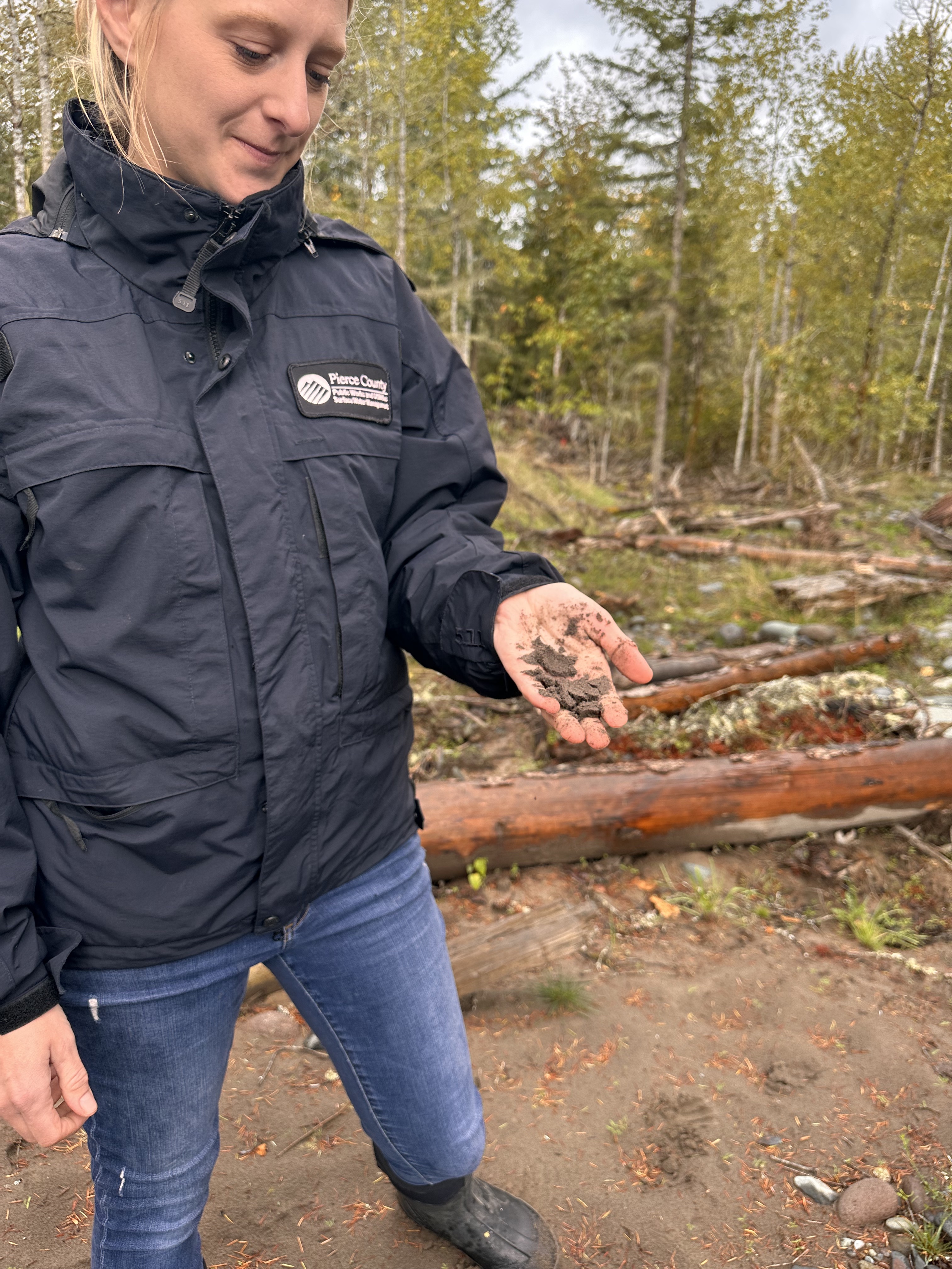 Kathleen Berger shows off sediment that accumulated along the river last year. (Credit: Lauren Gallup / NWPB) 