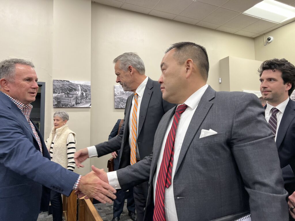 WSU athletic director Pat Chun and OSU athletic director Scott Barnes shake hands following their legal victory in Whitman County Superior Court