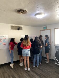 Othello teenagers write on whiteboards as they jot down their ideas for their dream community.