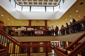 Students stand along the railing above double staircases in a well lit building on the Pullman WSU campus. 