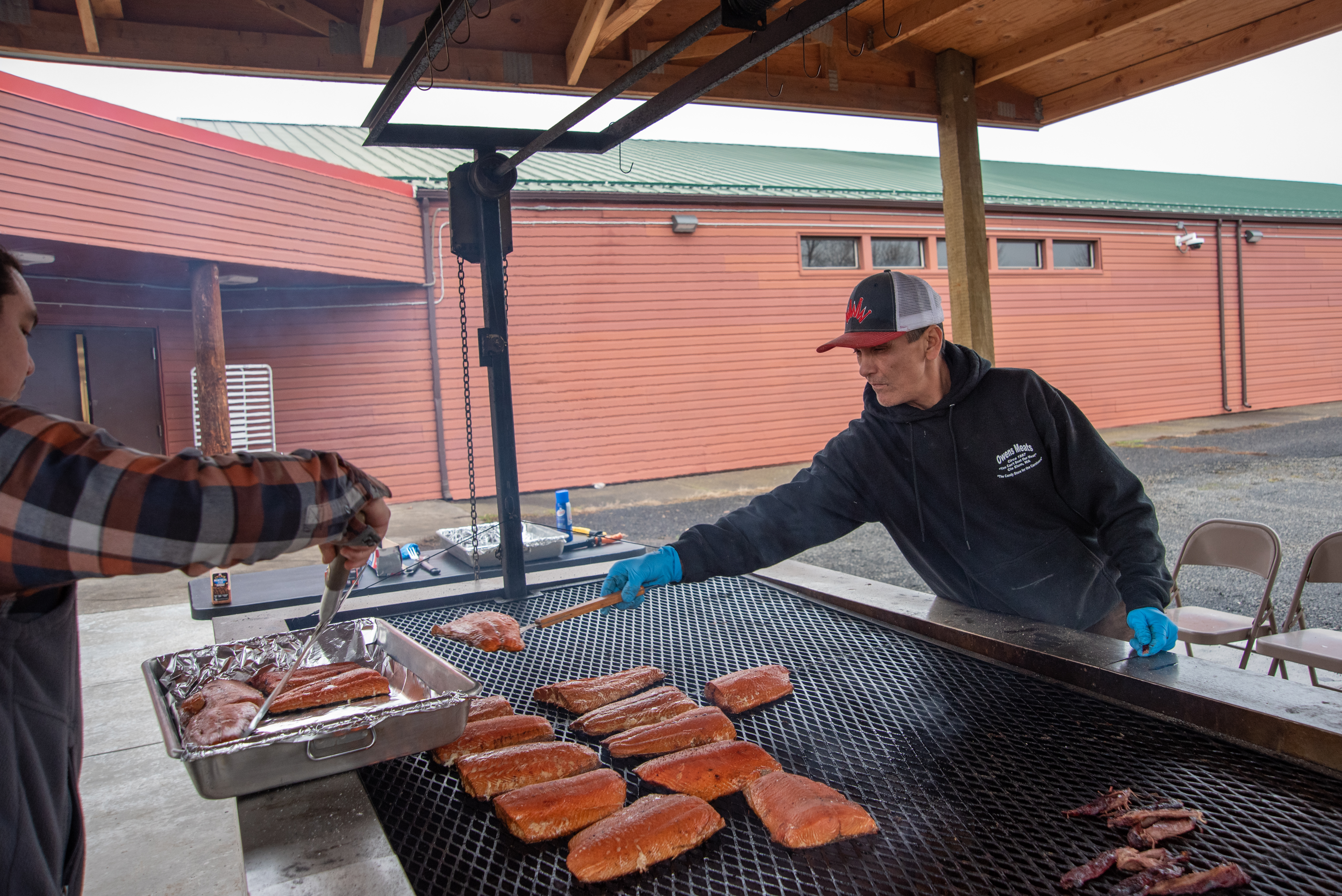 Longhouse cooks Freddy WarBonnet, right, and Andrew Wildbill grill up salmon, an important first food, for the Confederated Tribes of the Umatilla Indian Reservation Indian New Year feast on Dec. 21 in Mission, Oregon