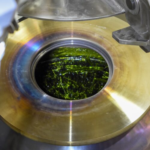 The poured glass appears emerald green, just before it’s lidded and transported to an export bay at Hanford in southeast Washington. Hanford officials are celebrating this first container of glass to be poured from the Waste Treatment Plant at the radioactive cleanup site. (Courtesy: Bechtel)