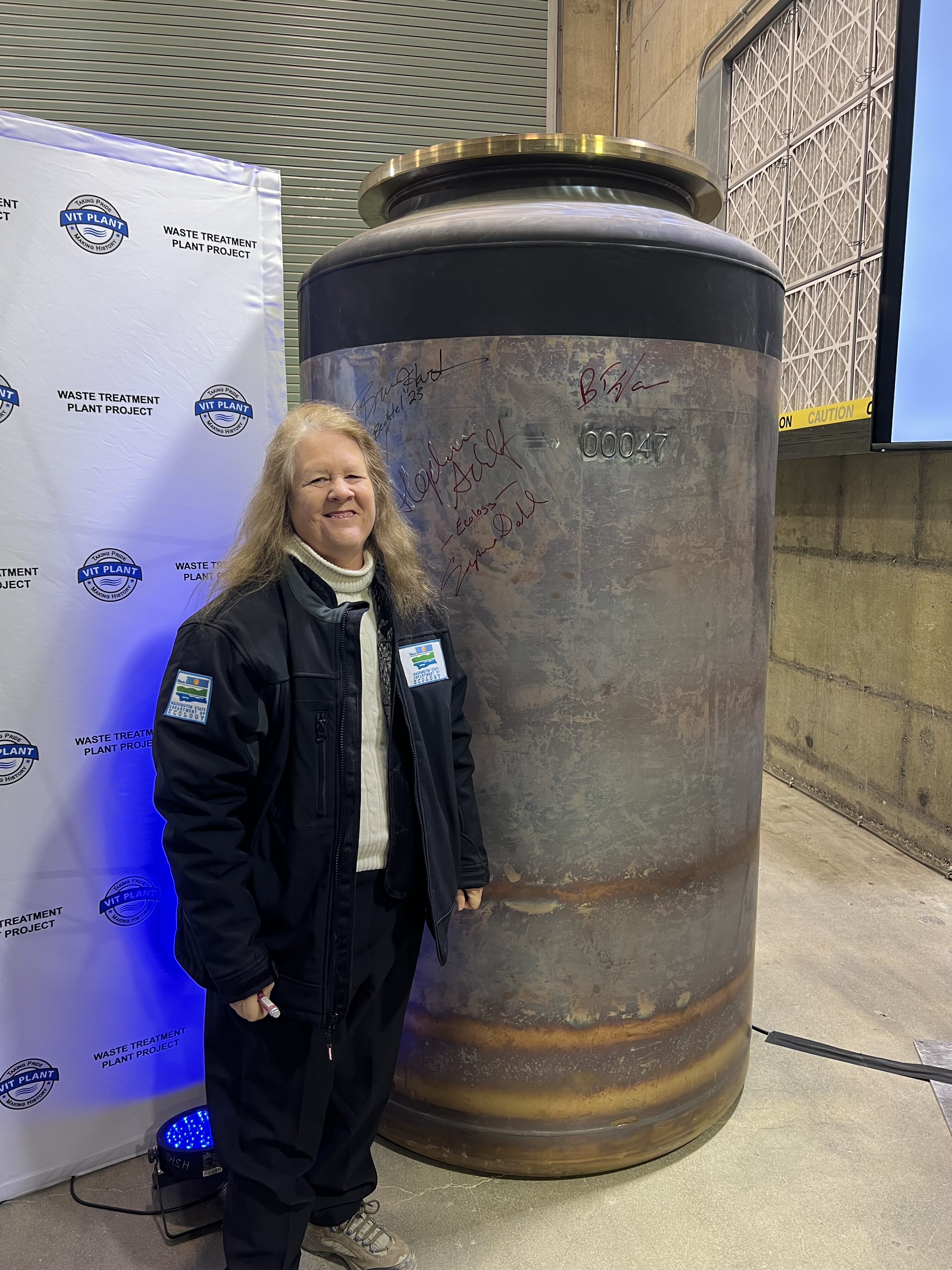 Washington Ecology’s Suzanne Dahl stands next to the first container of glass poured at the Waste Treatment Plant at Hanford