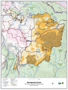 A color coded map in pink, green, brown, and gold shows the management areas for the Nez-Perce Clearwater National Forest on a large map.