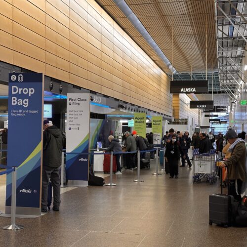 Passengers move through lines to check baggage for upcoming Alaska Airlines' flights, while others wait, some for flights delayed, on Tuesday, Jan. 9. (CREDIT: Lauren Gallup / NWPB)