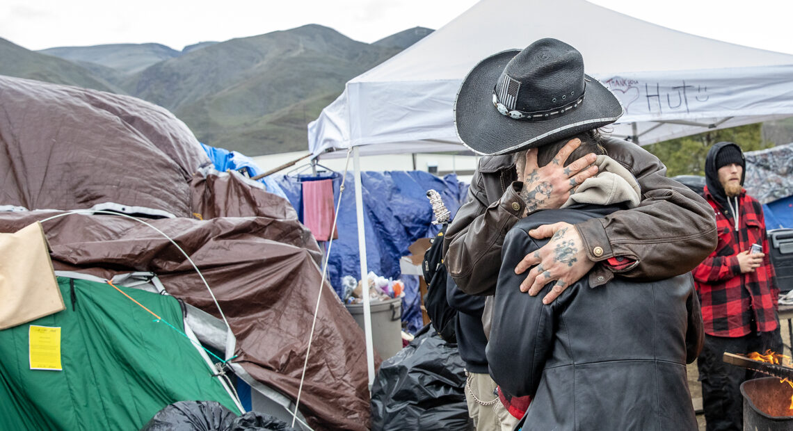 John "Cowboy" Park hugs Tiffany Deen after being served notices of trespass by Clarkston Police in Clarkston. Camp residents say they were grateful to discover they had until Feb. 12 to vacate the property. (Credit: August Frank / Lewiston Tribune)