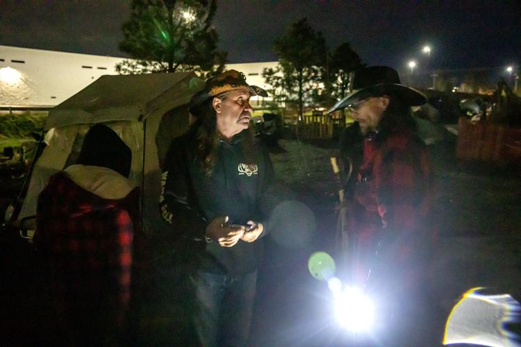 Cory James (left) talks with John "Cowboy" Parke as the remaining unhoused residents pack up their belongings at the homeless camp in Clarkston Monday evening. (Credit: August Frank / the Lewiston Tribune)