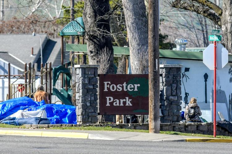 An unhoused person sits with their belongings at Foster Park. (Credit: August Frank / Lewiston Tribune)